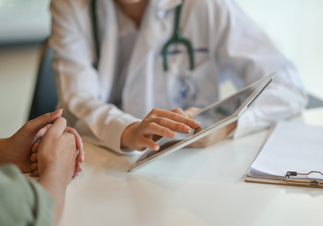 Shot of a doctor showing a patient some information on a digital tablet